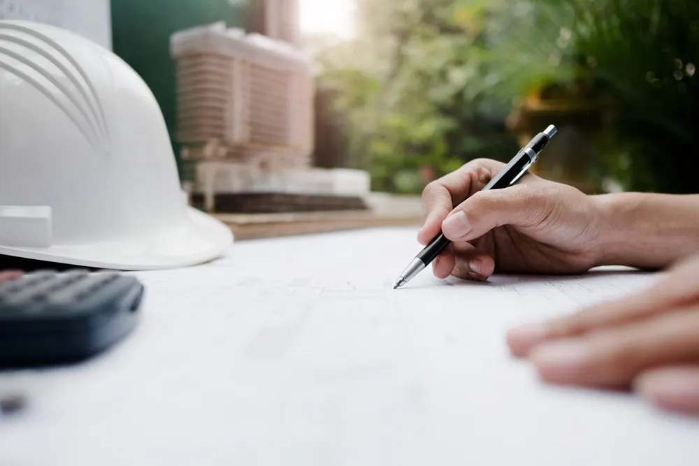 Engineer working closely on architectural blueprints