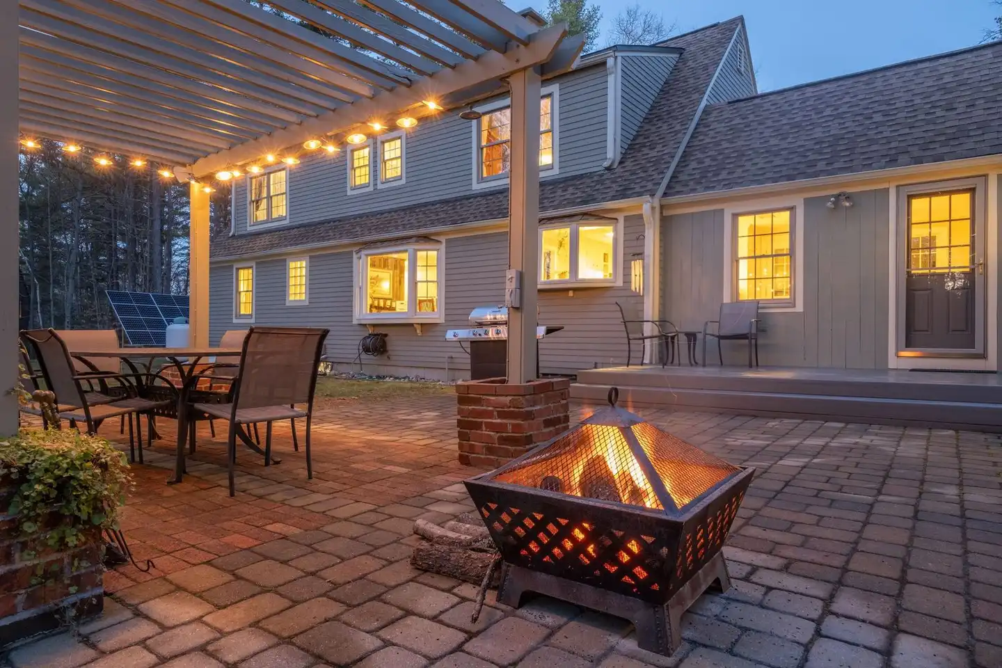 Brick masonry fire feature on a backyard paver patio at dusk